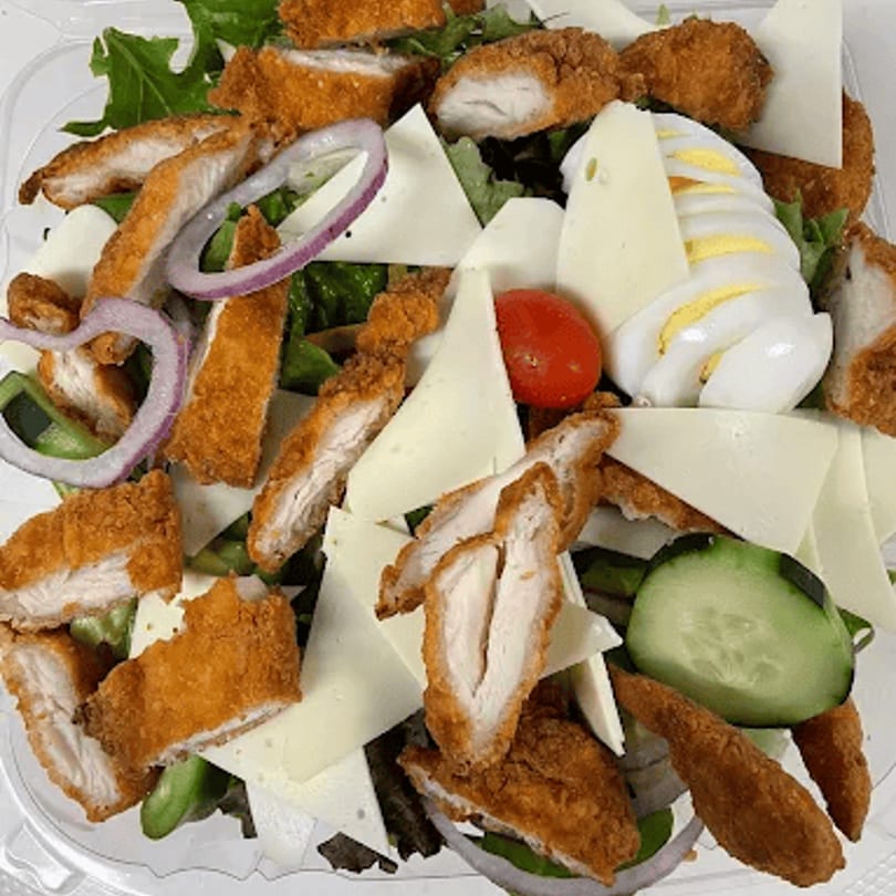 Crispy chicken cutlets, cheese, red onion, tomato, cucumber, and hard-boiled egg on a bed of greens.